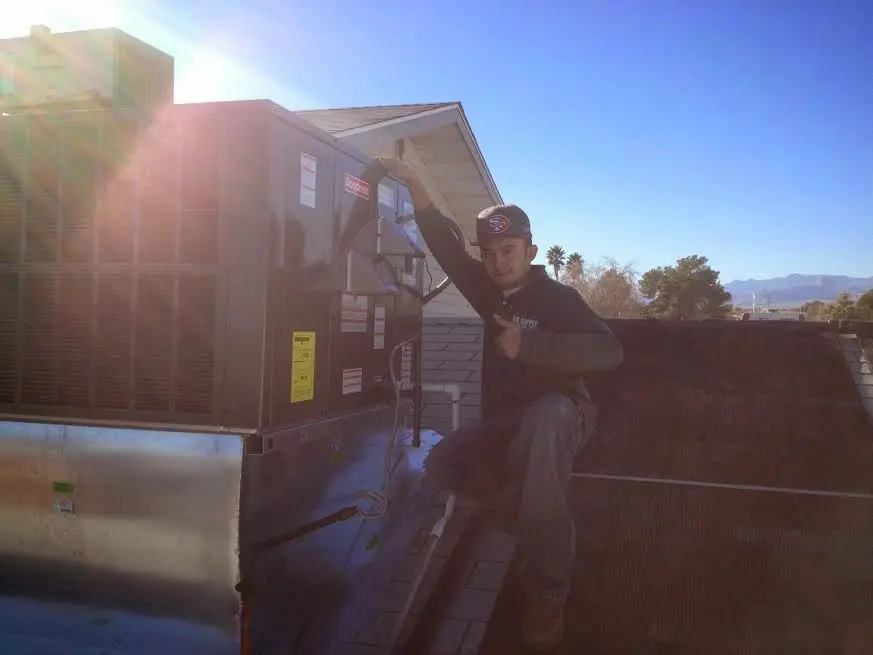HVAC technician performing AC Tune-Up on a rooftop unit in Naples